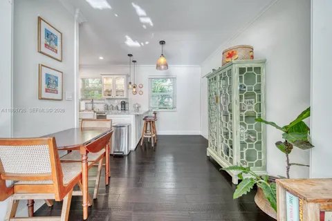 a dining room with furniture and a potted plant