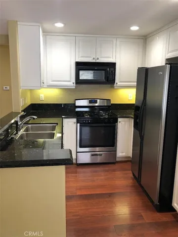 a kitchen with stainless steel appliances a stove a sink and a microwave