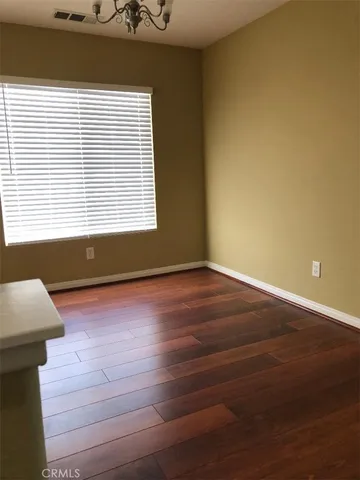 a view of a room with wooden floor and a window