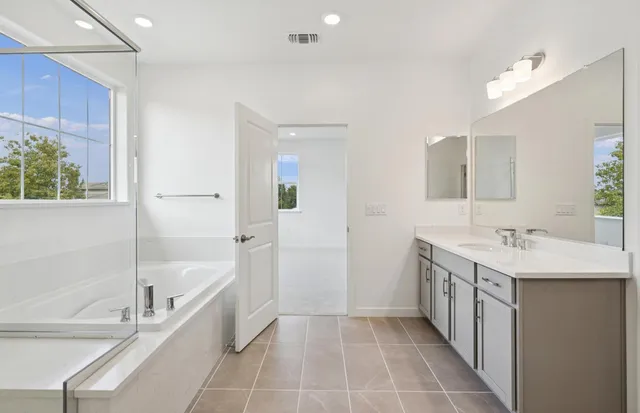 a bathroom with a bathtub a sink a vanity and a shower