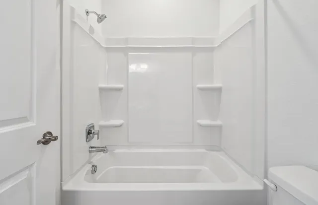 a white bath tub sitting next to a white sink and vanity