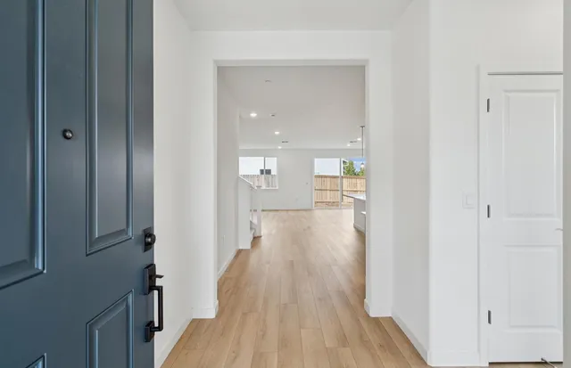 a view of a hallway with wooden floor and closet area