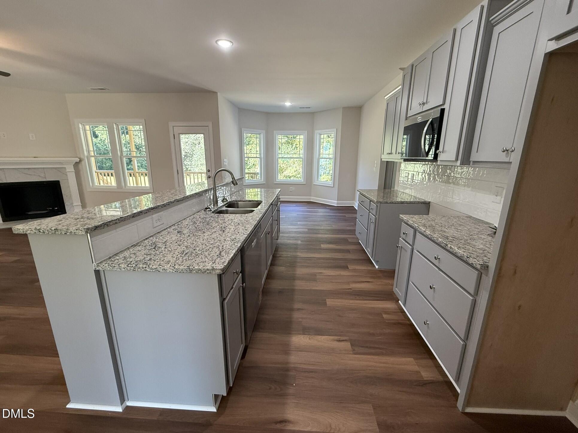 309 Busterfield Court Benson, NC 27504 - Photo 11 of 27 a large kitchen with granite countertop a sink and dishwasher a stove with wooden floor