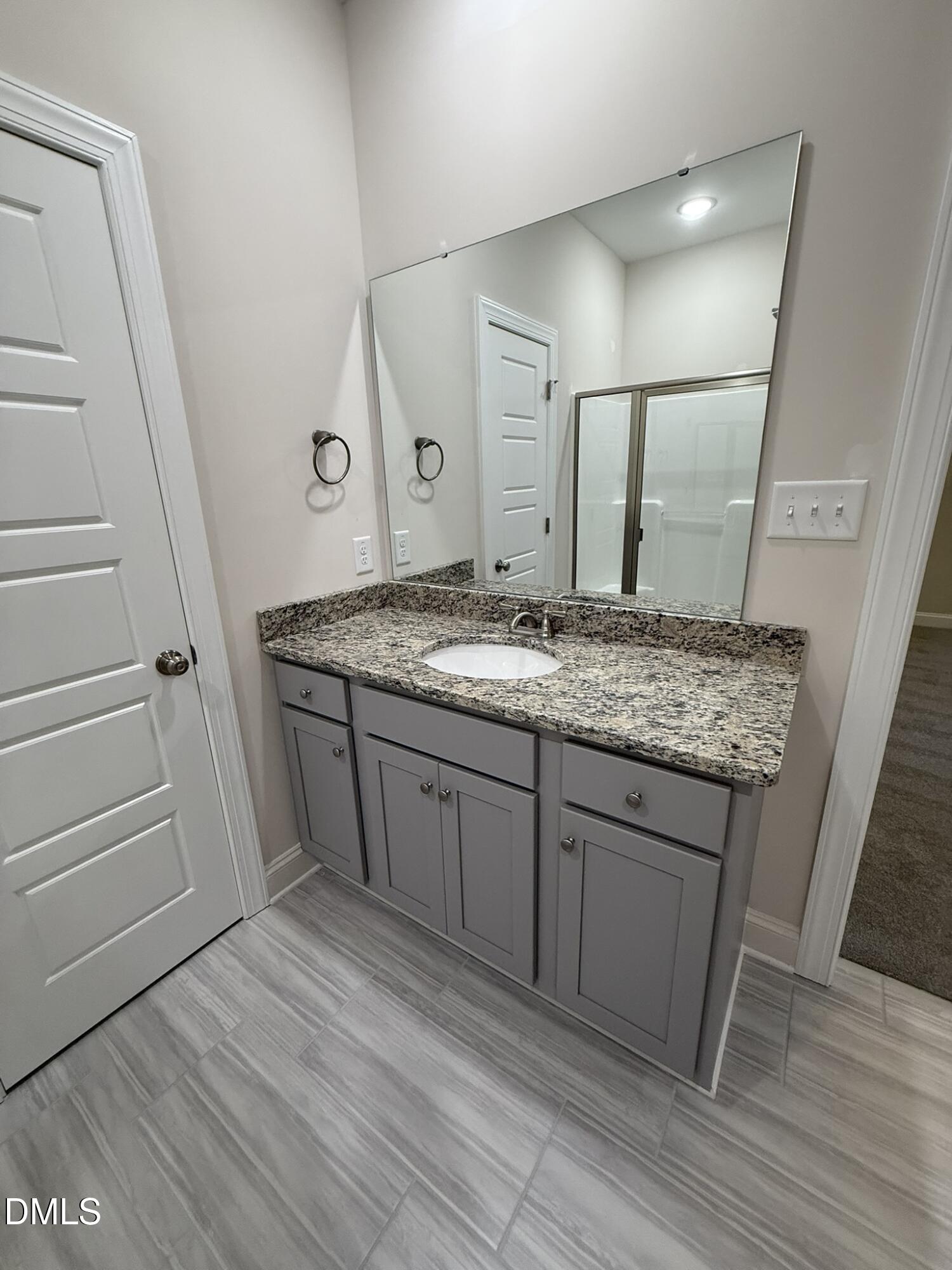 309 Busterfield Court Benson, NC 27504 - Photo 16 of 27 a spacious bathroom with a granite countertop sink and a mirror