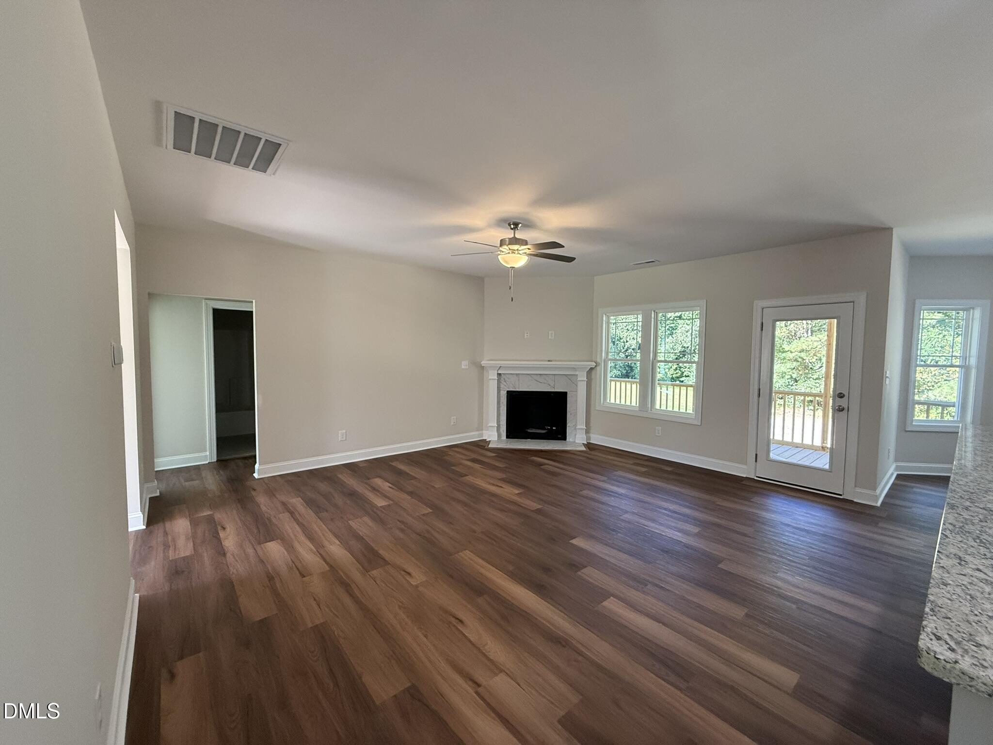 309 Busterfield Court Benson, NC 27504 - Photo 6 of 27 a view of an empty room with wooden floor and a window