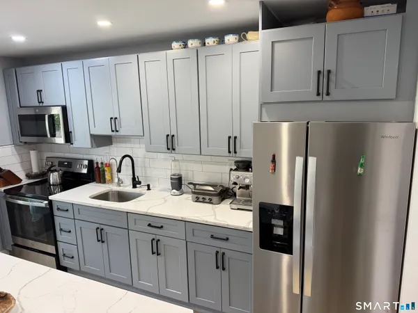 a kitchen with stainless steel appliances granite countertop a refrigerator sink and cabinets
