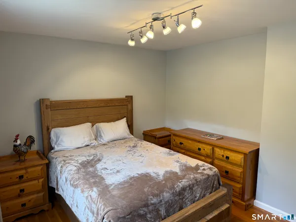 a bedroom with a bed and wooden floor
