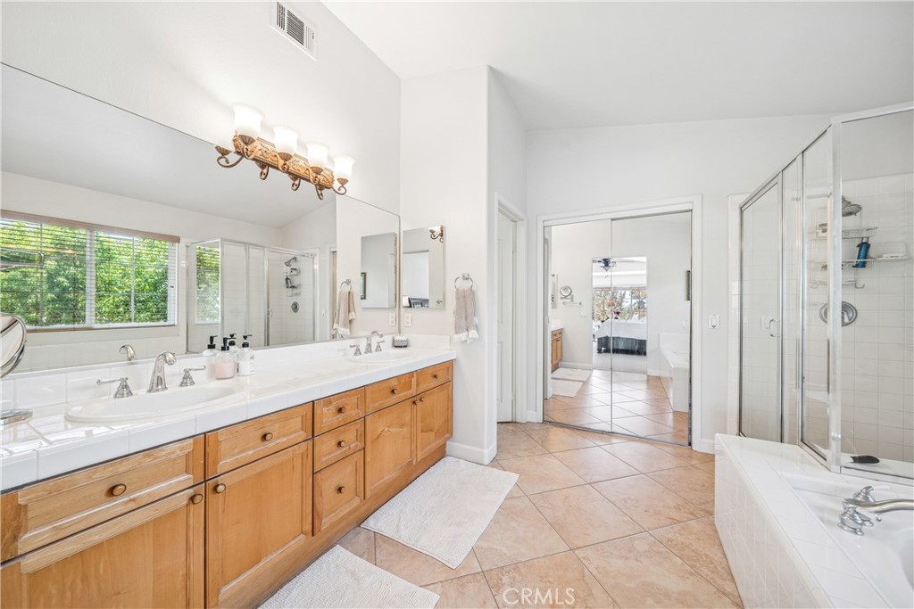 22681 Maplewood Mission Viejo, CA 92692 - Photo 28 of 71 a spacious bathroom with a double vanity sink a mirror a bathtub and shower