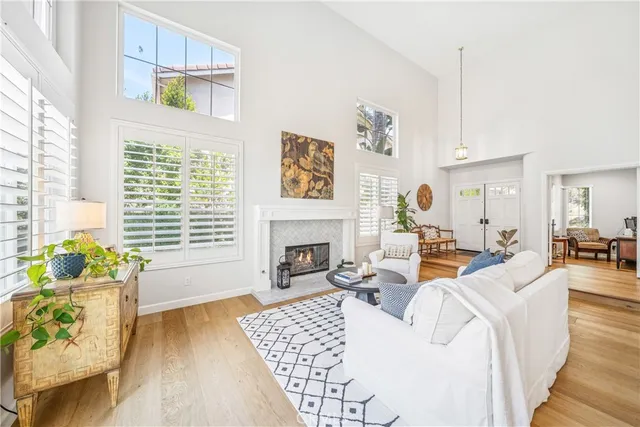 a living room with furniture and a dining table with wooden floor