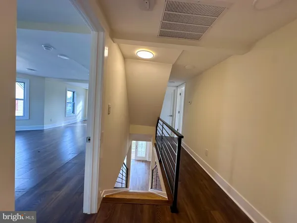a view of a hallway with wooden floor and staircase
