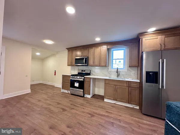 a kitchen with granite countertop a refrigerator stove top oven and sink