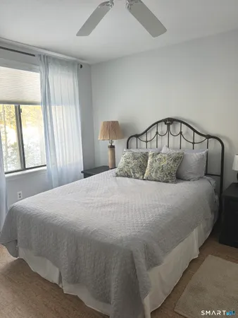 a bedroom with bed couch and window