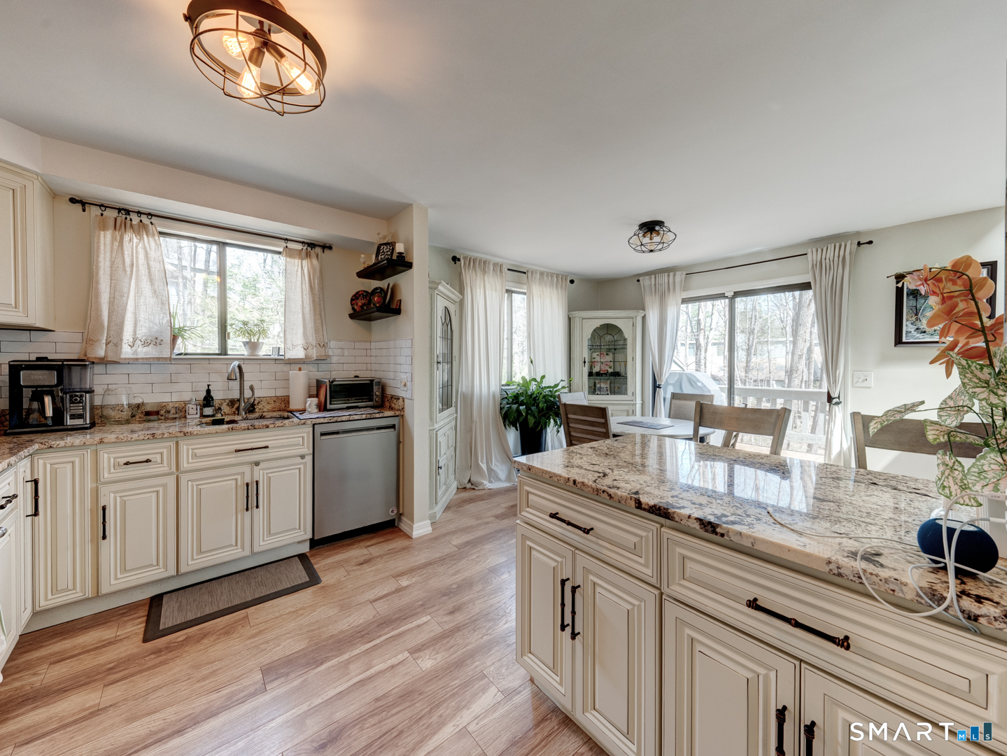 355 Ledge Drive, Unit 355 Torrington, CT 06790 - Photo 21 of 58 a kitchen with granite countertop a stove a sink a dining table and chairs