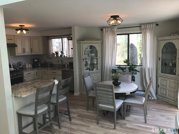 a dining room with furniture a chandelier and wooden floor