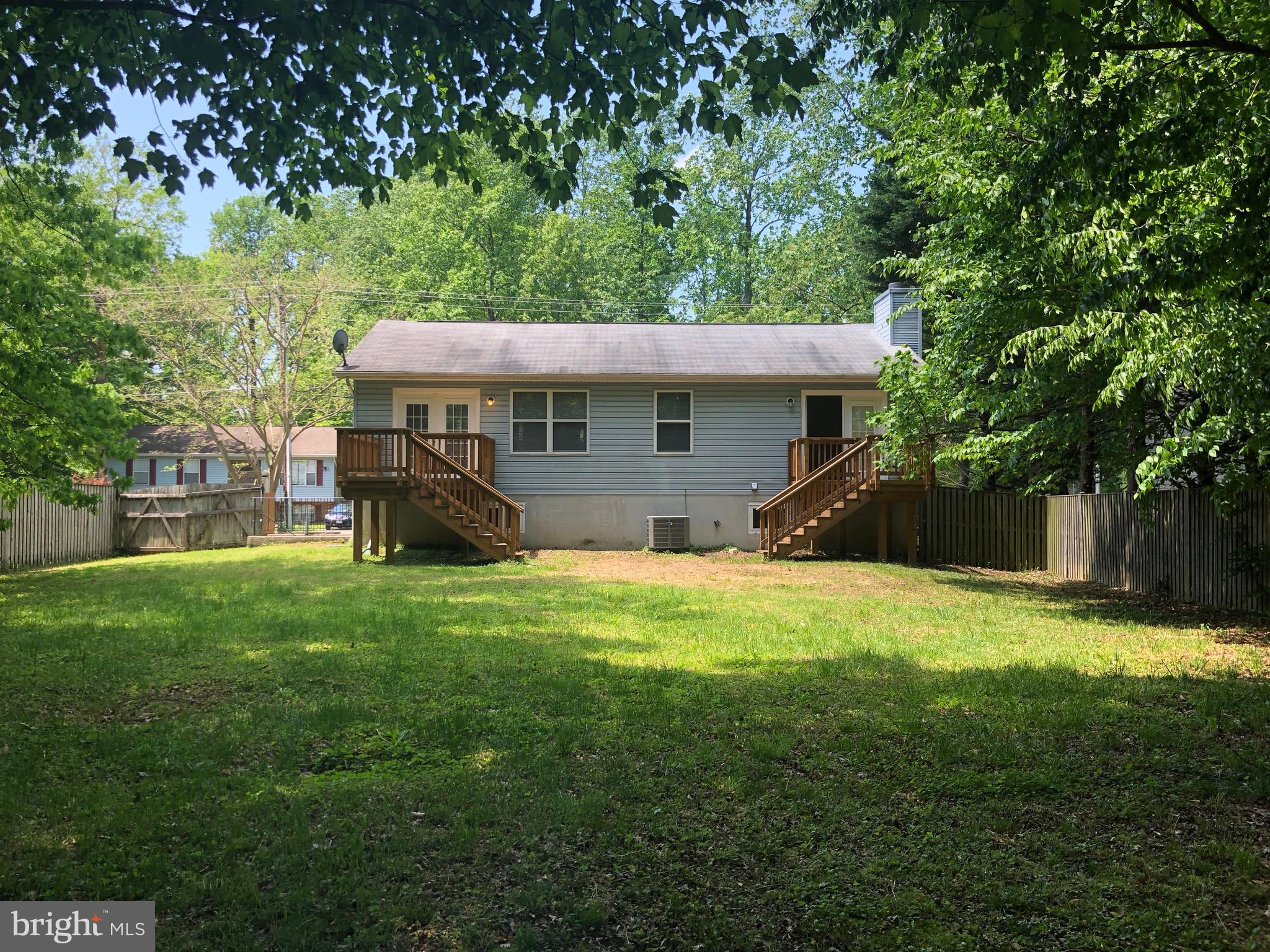 11234 Commanche Road Lusby, MD 20657 - Photo 20 of 21 a view of a backyard with table and chairs under an umbrella