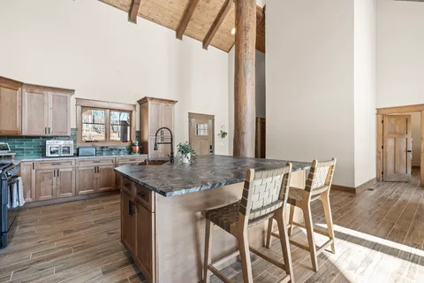 a dining hall with stainless steel appliances granite countertop a stove and a wooden floors