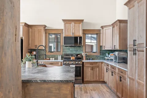 a kitchen with stainless steel appliances granite countertop a sink stove and cabinets