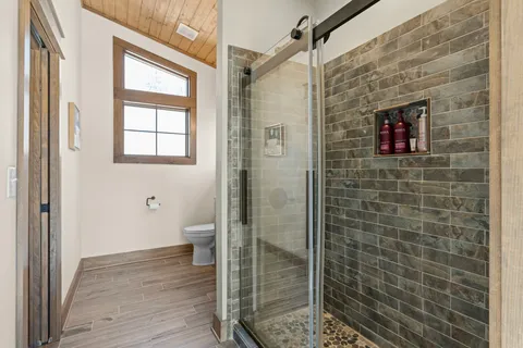 a bathroom with a granite countertop toilet a sink and shower