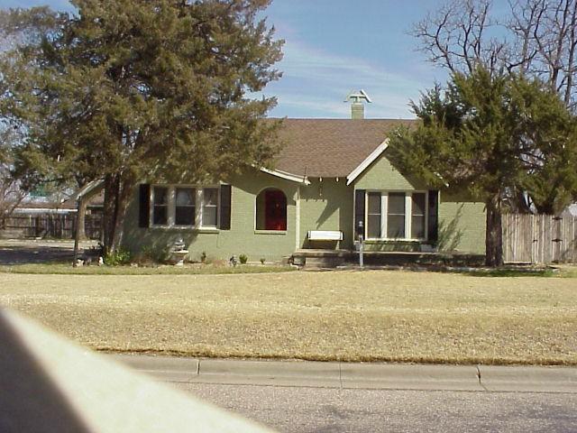 a view of a house with a yard and large tree