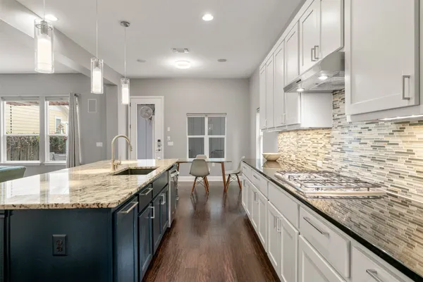 a kitchen with granite countertop a sink stove and cabinets