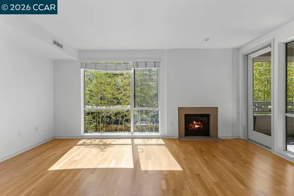 a view of an empty room with a fireplace and a window
