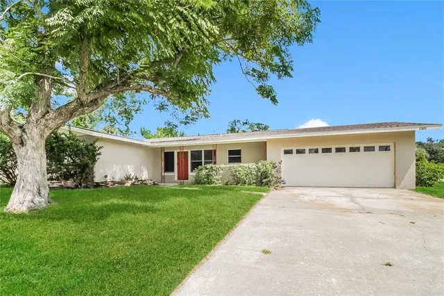 a view of a house with a yard and potted plants