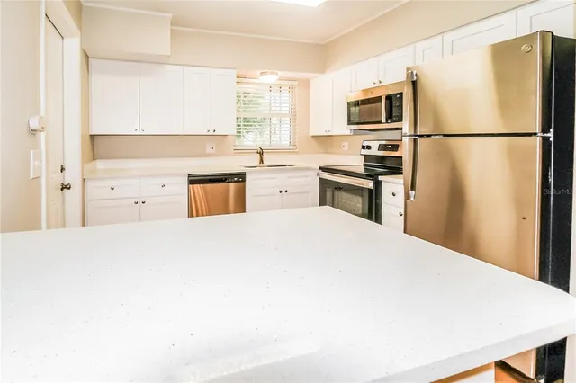 a kitchen with a refrigerator stove and microwave