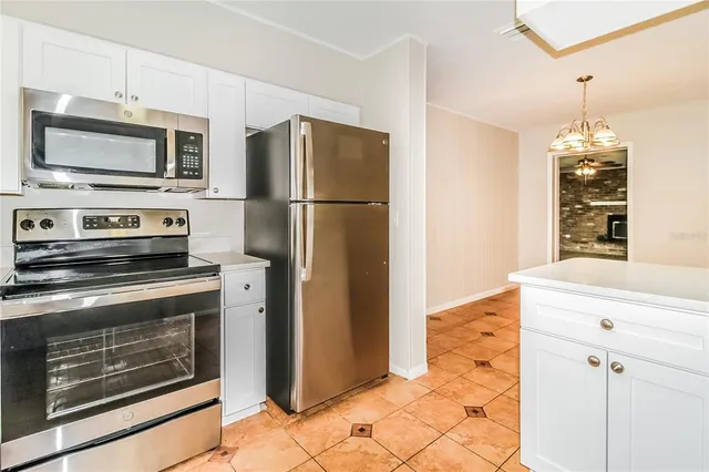 a kitchen with granite countertop a refrigerator stove and microwave