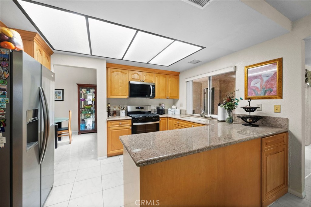 605 Bronco Way Walnut, CA 91789 - Photo 17 of 69 a kitchen with stainless steel appliances granite countertop a sink a stove and a refrigerator