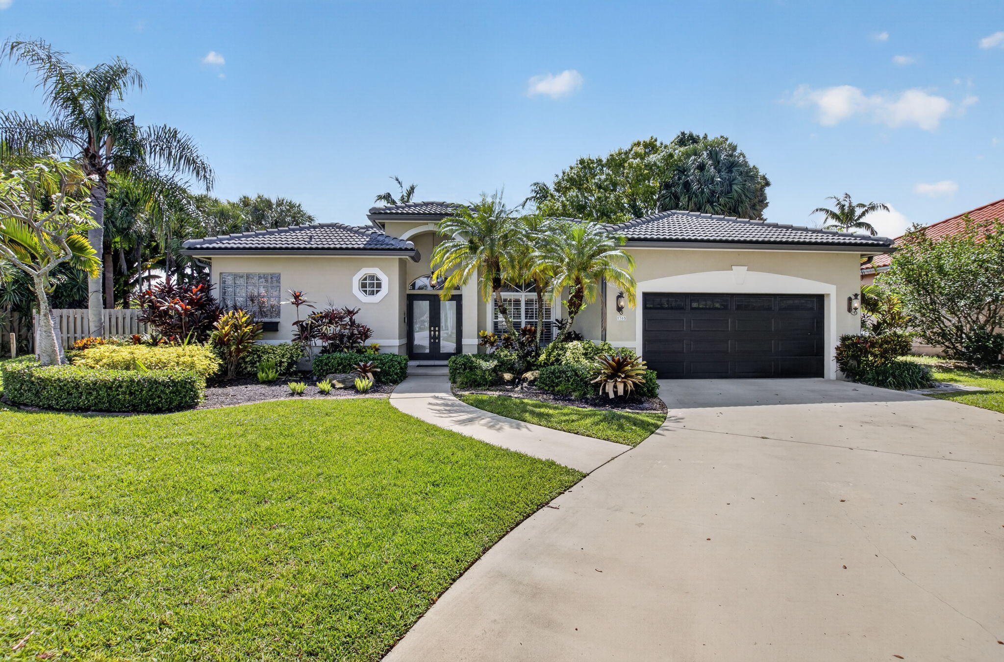 1365 East Barwick Ranch Circle Delray Beach, FL 33445 - Photo 1 of 77 a front view of a house with a yard and garage