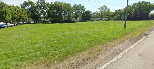 a view of a field of grass and trees
