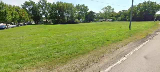 a view of a field of grass and trees