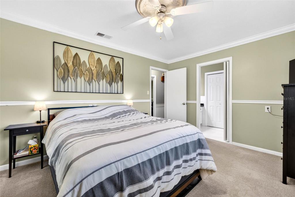 16330 Hanna Road Lutz, FL 33549 - Photo 22 of 41 a bedroom with a large bed and a chandelier
