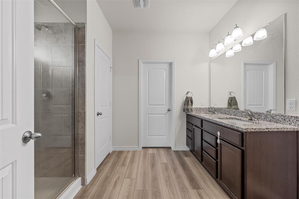 10712 Peperak Court Waco, TX 76708 - Photo 15 of 25 a bathroom with a granite countertop sink a large mirror and shower