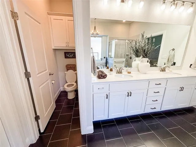 a bathroom with a double vanity sink a mirror and a shower
