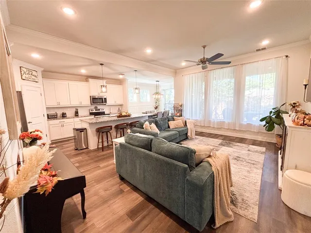 a living room with stainless steel appliances kitchen island granite countertop furniture and a large window