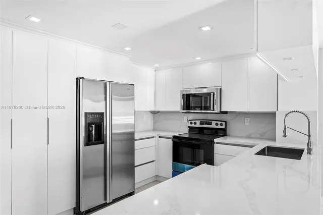 a kitchen with stainless steel appliances granite countertop a refrigerator sink and stove