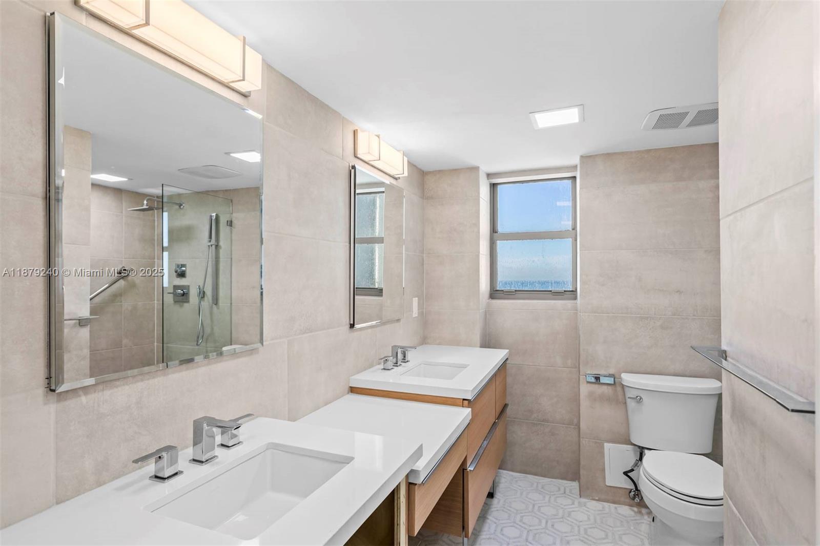 5555 Collins Avenue, Unit 14N Miami Beach, FL 33140 - Photo 7 of 16 a bathroom with a sink a toilet and shower