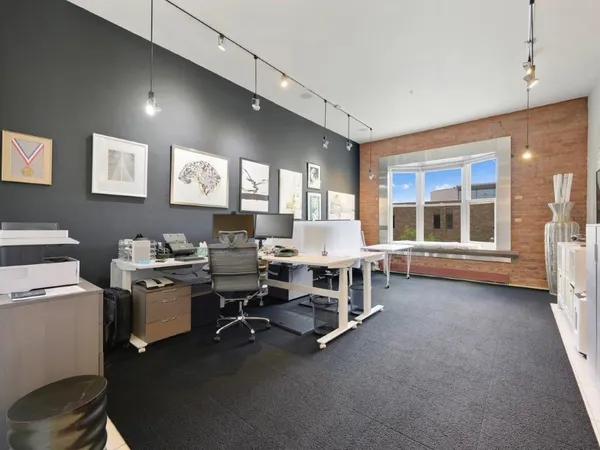 a view of a workspace with furniture and a window