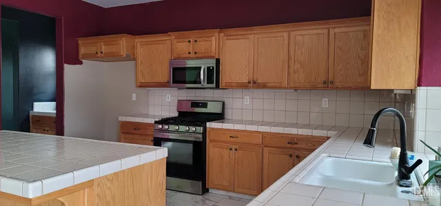 a kitchen with a sink a stove and cabinets
