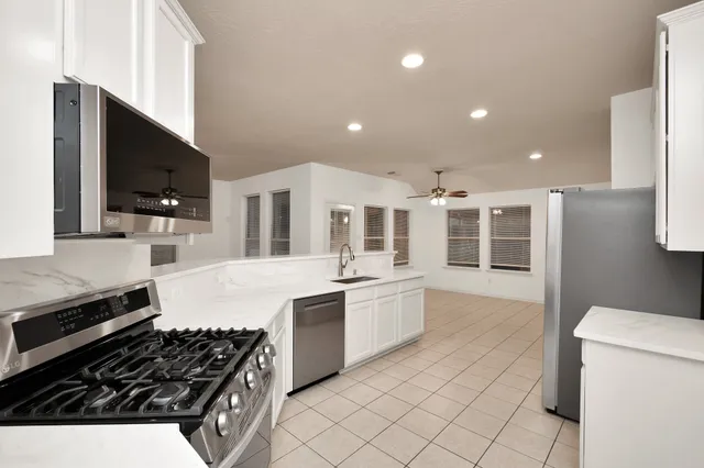 a kitchen with stainless steel appliances granite countertop a stove and a sink