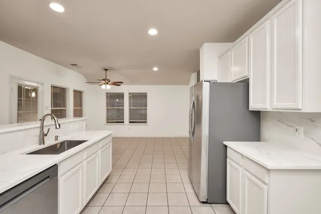 a kitchen with a sink a refrigerator and cabinets