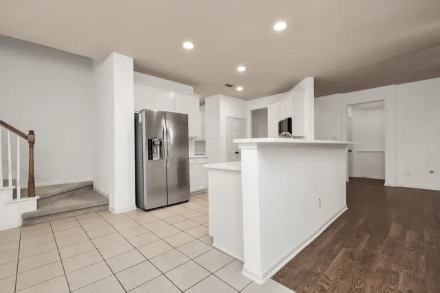 a kitchen with stainless steel appliances a refrigerator and a stove top oven