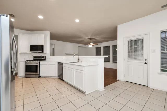 a kitchen with white cabinets a sink and white appliances