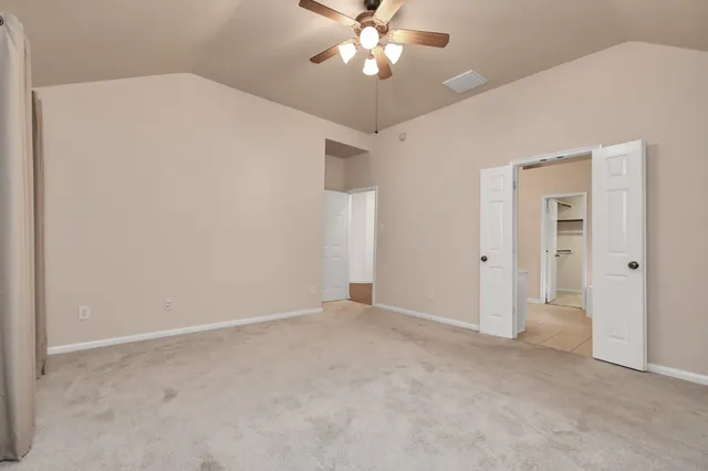 an empty room with closet and a chandelier fan