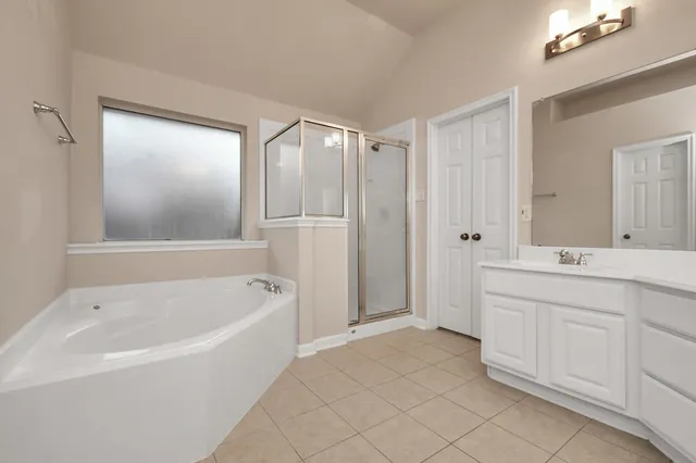 a spacious bathroom with a tub sink and mirror