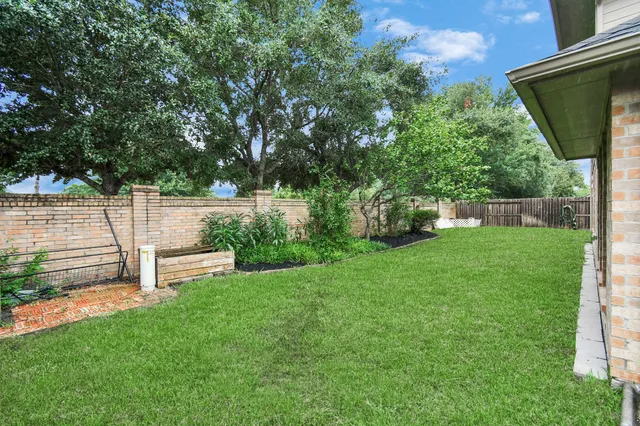 a view of a backyard with wooden fence and a bench