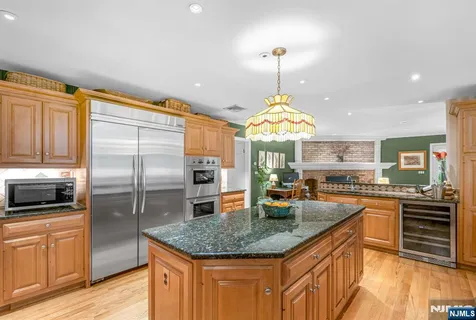 a kitchen with stainless steel appliances granite countertop a sink a stove and refrigerator