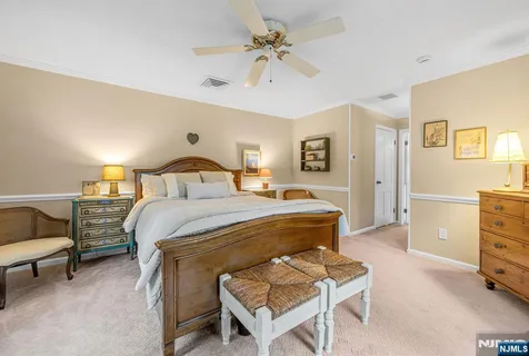 a bedroom with a bed a chair and a dresser