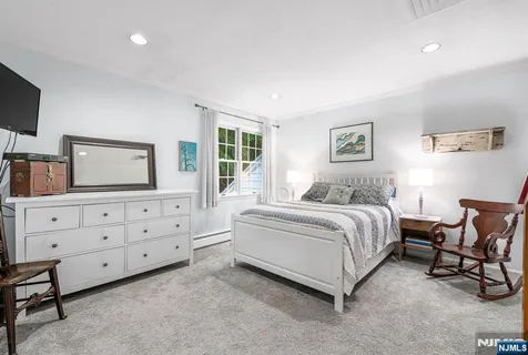 a spacious bedroom with a large bed and a dresser